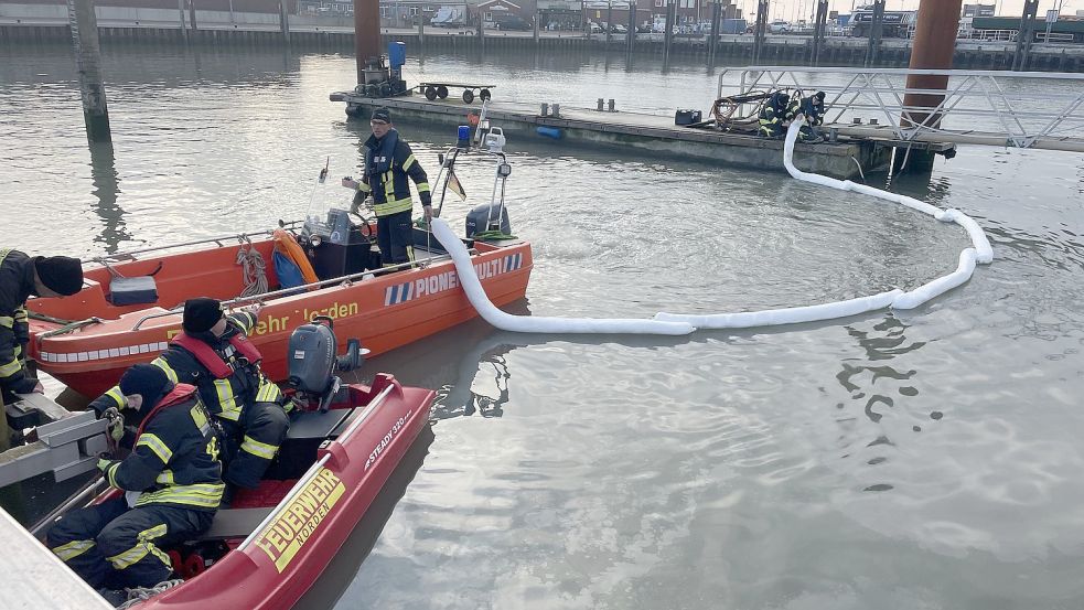 Einsatzkräfte der Feuerwehr legen Ölsperren aus. Foto: Feuerwehr