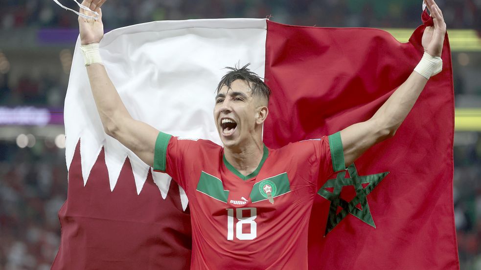 Youssef En-Nesyri feiert den Viertelfinalsieg mit einer marokkanischen und katarischen Fahne. Foto: imago-images/Agencia EFE