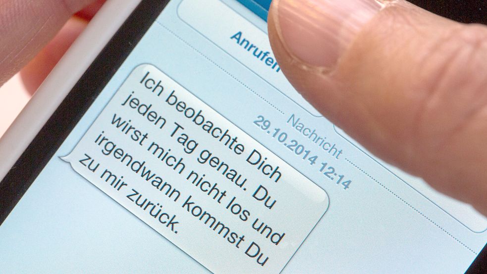 Auf einem Smartphone ist eine SMS eines Stalkers zu lesen. Foto: DPA