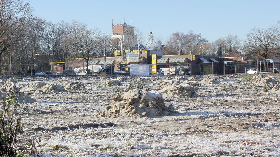 Die Sandhügel zeugen von der Arbeit des Kampfmittelräumdienstes, der die Fläche bis in mehrere Meter Tiefe untersuchte. Im Hintergrund ist der jetzige Edeka-Markt Kruse auf der anderen Straßenseite zu sehen. Foto: Karin Böhmer