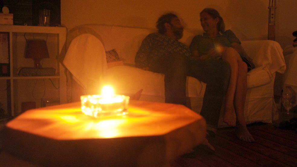 Ein Paar sitzt während eines Stromausfalls bei Kerzenschein in einer Wohnung. Was passiert im Fall des Blackouts? Darauf bereitet sich gerade die Stadt Norden vor. Foto: DPA