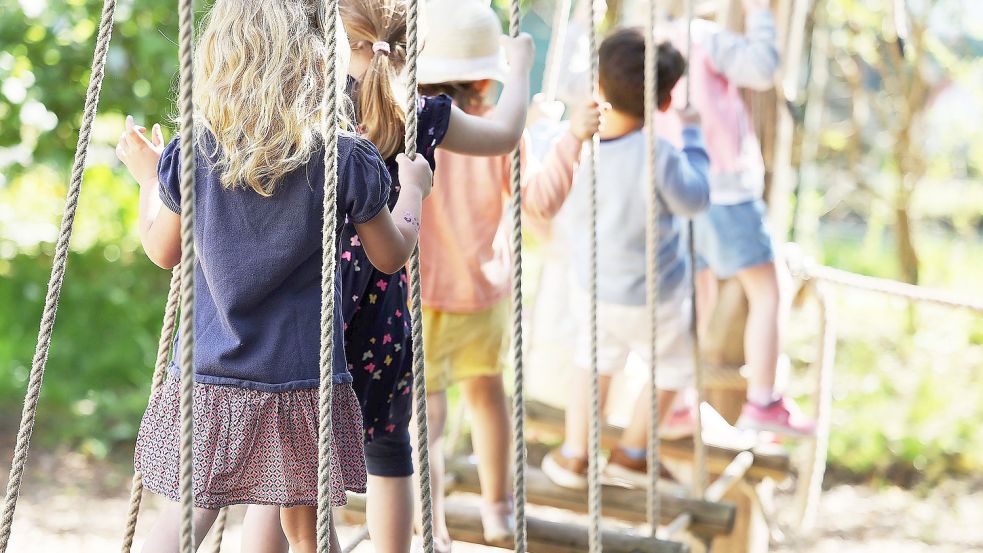 Kinder laufen in der Kindertagesstätte über eine Hängebrücke. Foto: DPA