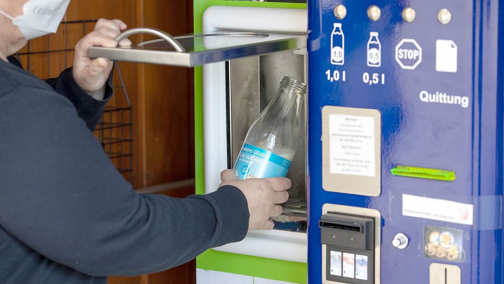 An einem Automaten wird Milch gezapft. Für den Betrieb solcher Milchtankstellen greifen neue Regeln. Foto: Friso Gentsch/DPA