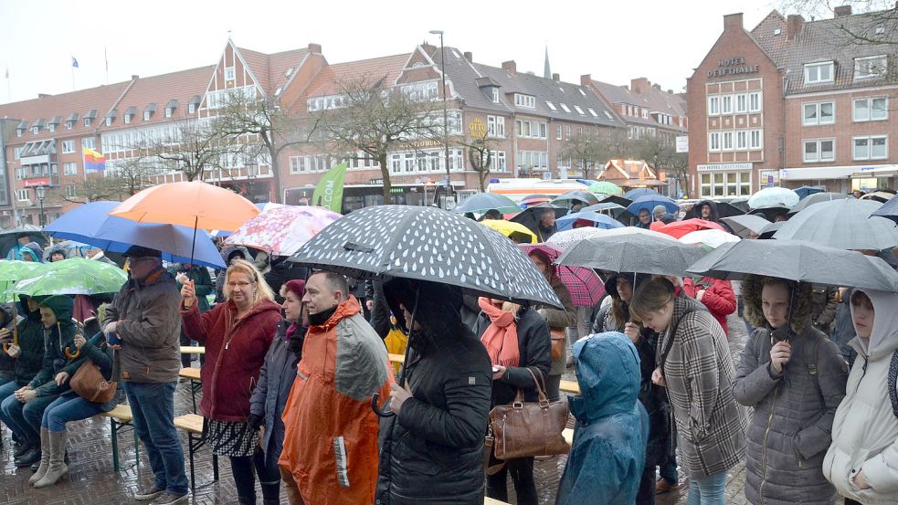 Die vielleicht 300 bis 400 Besucher auf dem Emder Rathausplatz schützten sich mit Schirmen vor dem kalten Januar-Regen. Foto: Aiko Recke