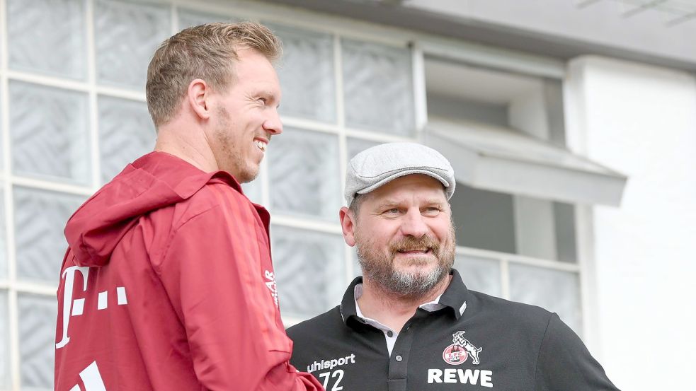 Bayerns Trainer Julian Nagelsmann (l) und Kölns Trainer Steffen Baumgart unterhalten sich. Foto: Silas Stein/dpa