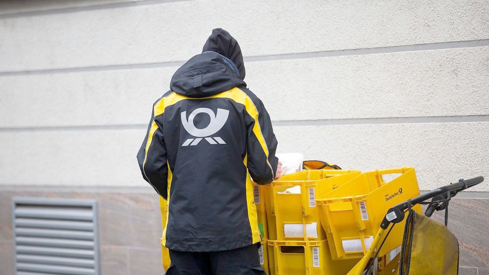 Ein Briefträger der Deutschen Post verteilt die Postsendungen an die Haushalte. Foto: Thomas Banneyer/dpa