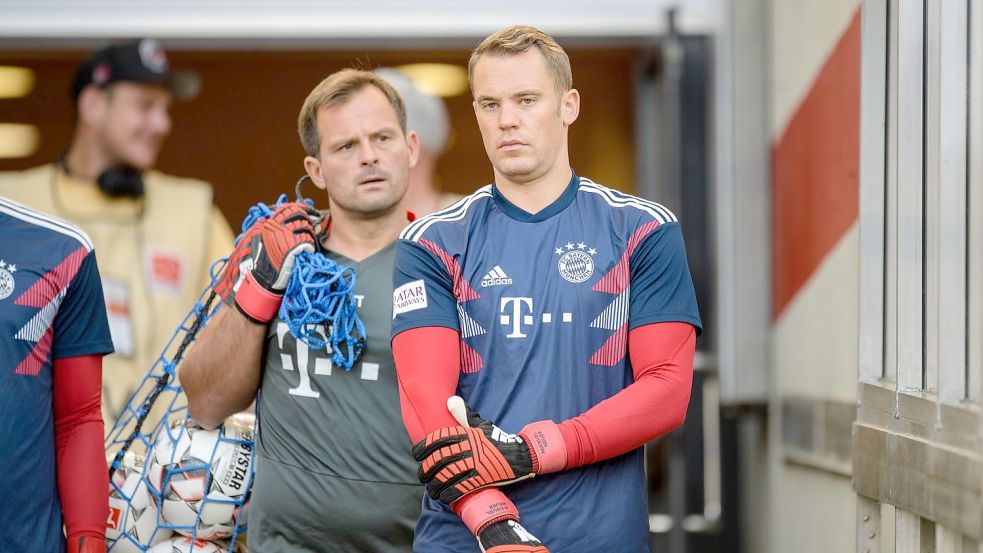 Manuel Neuer vom FC Bayern München (r) kommt mit Torwarttrainer Toni Tapalovic aus dem Spielertunnel. Foto: Matthias Balk/dpa
