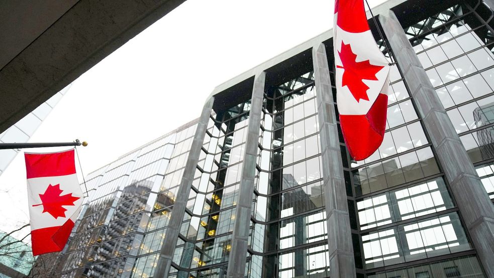 Die Nationalflagge von Kanada weht vor dem Gebäude der Bank of Canada. Die Notenbank hebt noch einmal den Leitzins an. Foto: Sean Kilpatrick/Canadian Press via ZUMA Press/dpa