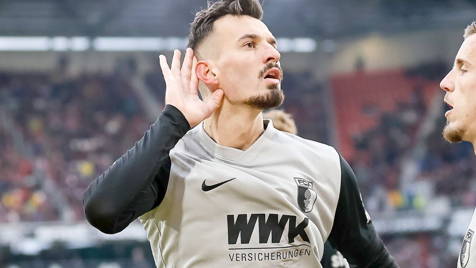 Augsburgs Mergim Berisha jubelt nach seinem Tor zum zwischenzeitlichen 1:1 gegen den SC Freiburg - vor den Freiburger Fans. Foto: imago images/Eibner