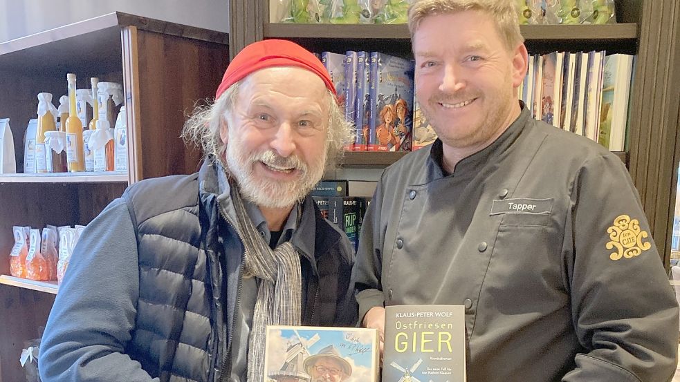 Auch im Norder Café Ten Cate haben sich Inhaber Jörg Tapper (rechts) auf den Start des mittlerweile 16. Ostfriesenkrimis von Klaus-Peter Wolf vorbereitet. Zahlreiche Fans bestellten ihr signiertes Buch samt spezieller Pralinenmischung vor. Foto: Rebecca Kresse