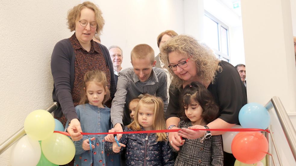 Das Kita-Team (von links) Jessyca Steffens, Dennis Eden und Hauke Müller durchschnitt mit der Hilfe von drei Kindern das rote Band zum Eingang der neuen Kita Lamberti. Foto: Heino Hermanns