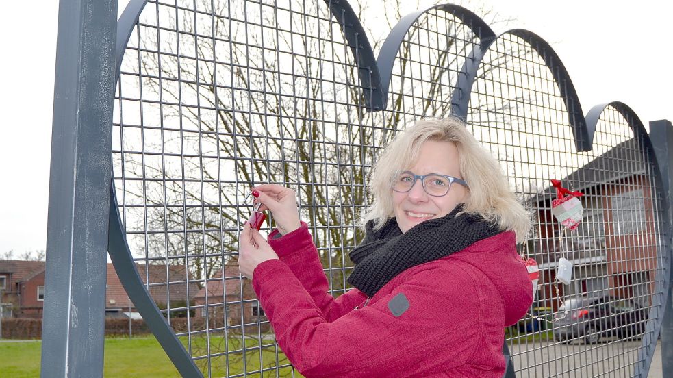 Die Auricher Pastorin Cathrin Meenken zeigt, wie es geht. Am Valentinstag sollen zahlreiche Schlösser die Stahlherzen schmücken. Foto: Neelke Harms