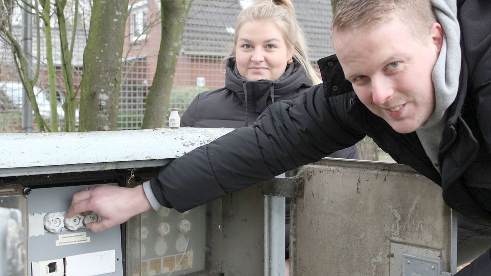 Vereinsvorsitzende Lina Bünting und Vorstandsmitglied Florian Börnsen sorgen sich um den Zustand der Flutlichtanlage auf dem Sportplatz neben der Grundschule. Der in die Jahre gekommene Sicherungskasten ist frei zugänglich. Schlüssel Fehlanzeige. Die Tür wird nur mit einem Stein gesichert. Foto: Wolf-Rüdiger Saathoff