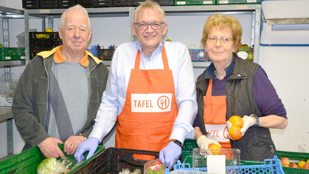 Landrat Olaf Meinen (Mitte) besuchte am Freitag die Auricher Tafel und ging dabei Ausgabestellenleiter Ernst Kuntner und Hannelore Schug bei ihrer ehrenamtlichen Arbeit zur Hand. Foto: Franziska Otto