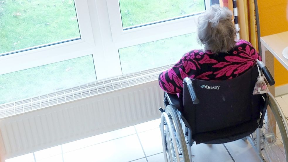 Die Bewohnerin eines Pflegeheims blickt aus einem Fenster. Foto: DPA