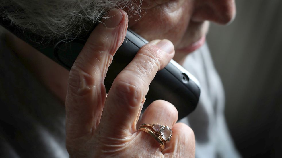 Eine ältere Frau telefoniert mit einem schnurlosen Festnetztelefon. In Ostfriesland werden viele Seniorinnen und Senioren durch den so genannten Enkeltrick oder Schockanruf um ihr Erspartes gebracht. Foto: DPA