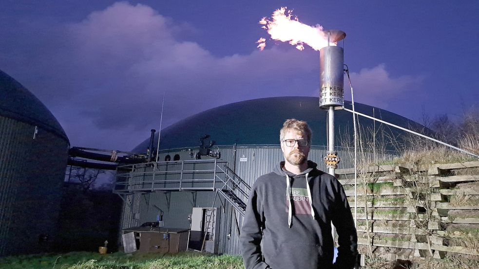 Landwirt Jens Soeken steht vor seiner Biogasanlage in Timmel. Über die Fackel muss er immer wieder Biogas verbrennen, wenn seine Anlage vom Netz genommen wurde. Foto: privat