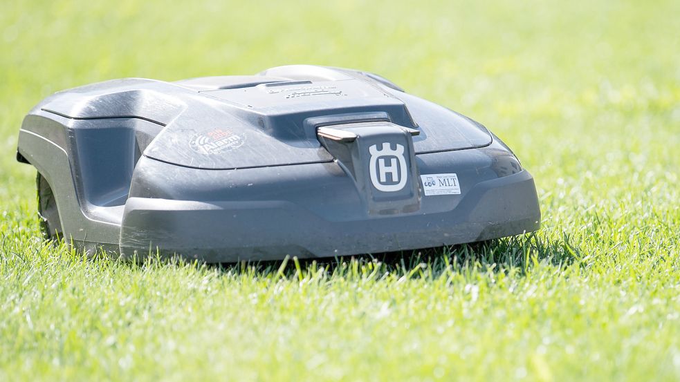 Ein Mähroboter dreht auf einem Rasen seine Runden. Foto: Sebastian Gollnow/DPA