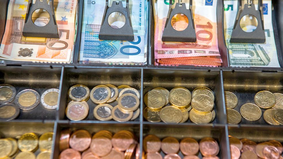 Eine mit Geldscheinen und Münzen gefüllte Ladenkasse. Foto: DPA