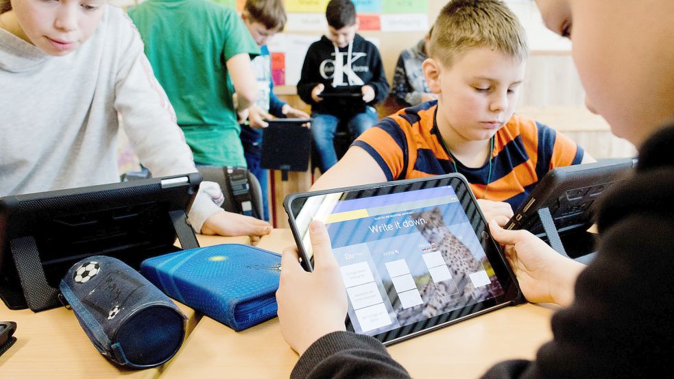 Kinder lernen in einer Schule mit Tablet-Computern. Nach und nach soll das auch in Südbrookmerland Realität werden. Foto: Julian Stratenschulte/DPA