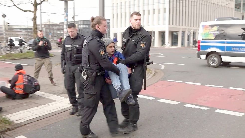 Aktivisten der Gruppe „Letzte Generation“ haben sich am Freitagmorgen im Bremer Zentrum auf eine Hauptverkehrsstraße geklebt. Sie wurden von der Polizei entfernt. Foto: NWM-TV