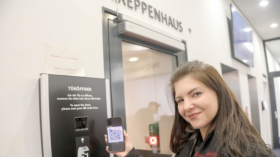 Lisa Ulferts vom Medienzentrum des Landkreises zeigt, wie das Scannen des QR-Codes funktioniert. Nur so gelangen Besucher ins Treppenhaus des Kreishauses. Foto: Romuald Banik