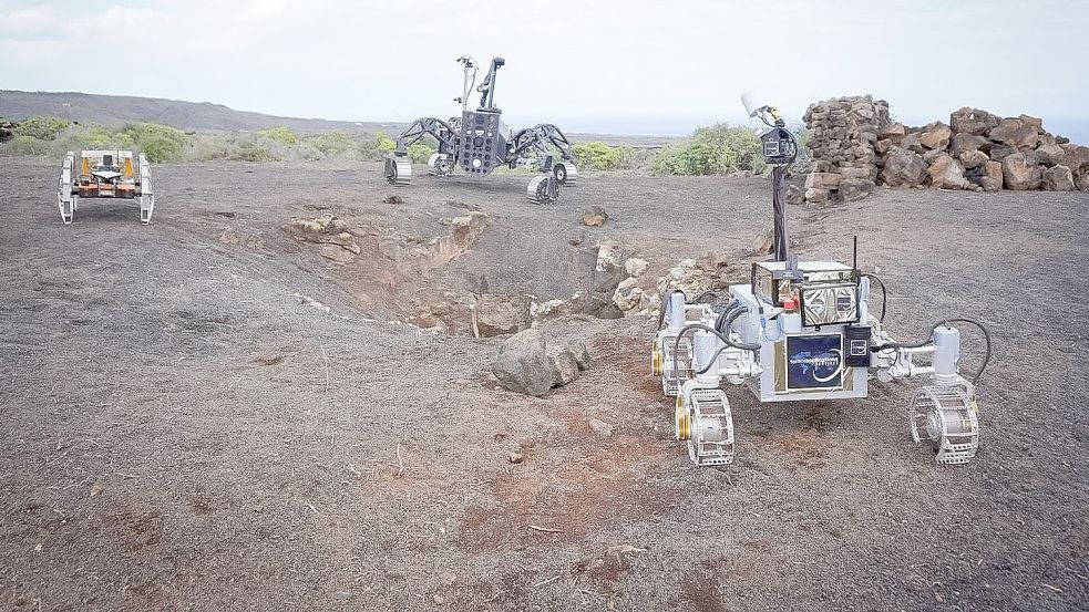 Die drei autonomen Rover Coyote III, SherpaTT und LUVMI-X erkunden den Eingang zu einer Lavahöhle auf Lanzarote. Foto: Tom Becker/DFKI/dpa