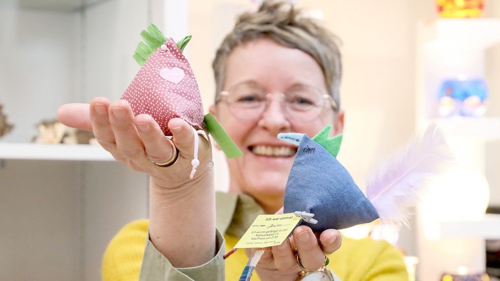 Herma Arends, Mitarbeiterin im Auricher Geschäft „Das Einhorn“, ist begeistert von den kleinen Stoffhühnern. Foto: Romuald Banik