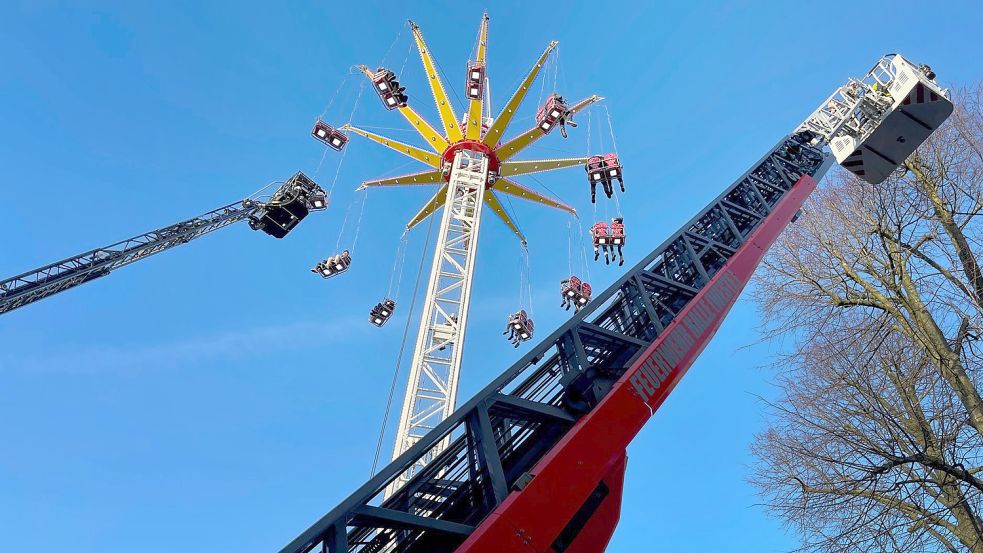 Menschen werden wegen eines Defekts in einem Kettenkarussell auf einer Kirmes in Halle (Westfalen) von der Feuerwehr mit Leiterwagen gerettet. Foto: dpa/Westfalennews/Christian Müller