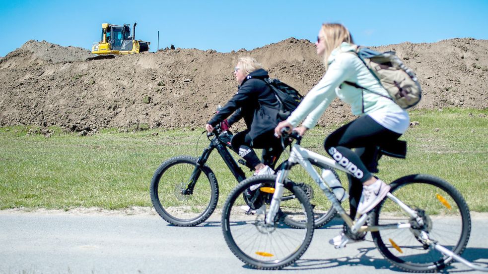 Eine Raupe fährt im Mai 2020 auf einem Deichabschnitt nahe der Ortschaft Hamswehrum. In einem jahrelangen Bauvorhaben werden im Gebiet der Deichacht Krummhörn die Küstenschutzbauwerke erhöht und verstärkt. Foto: DPA