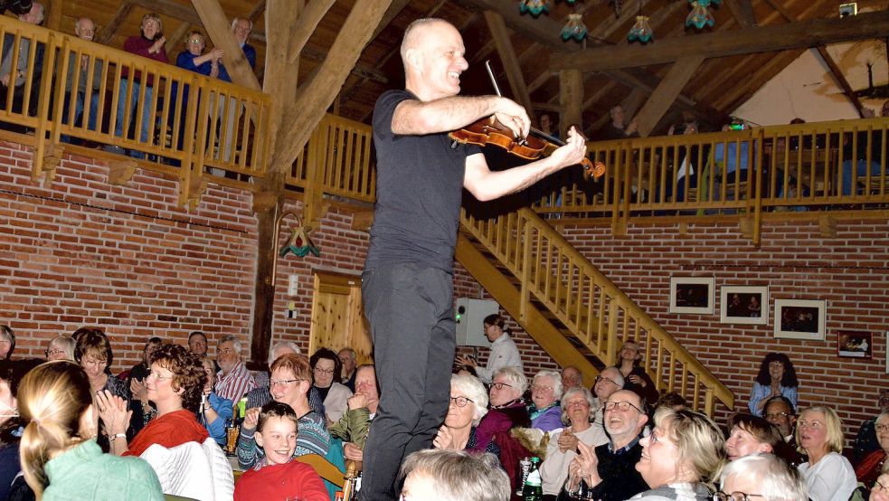 Frontmann Johannes Epremian: Hin zu den Fans – Dauerpower auf den Gulfhof-Tischen. Foto: Gerd-D. Gauger