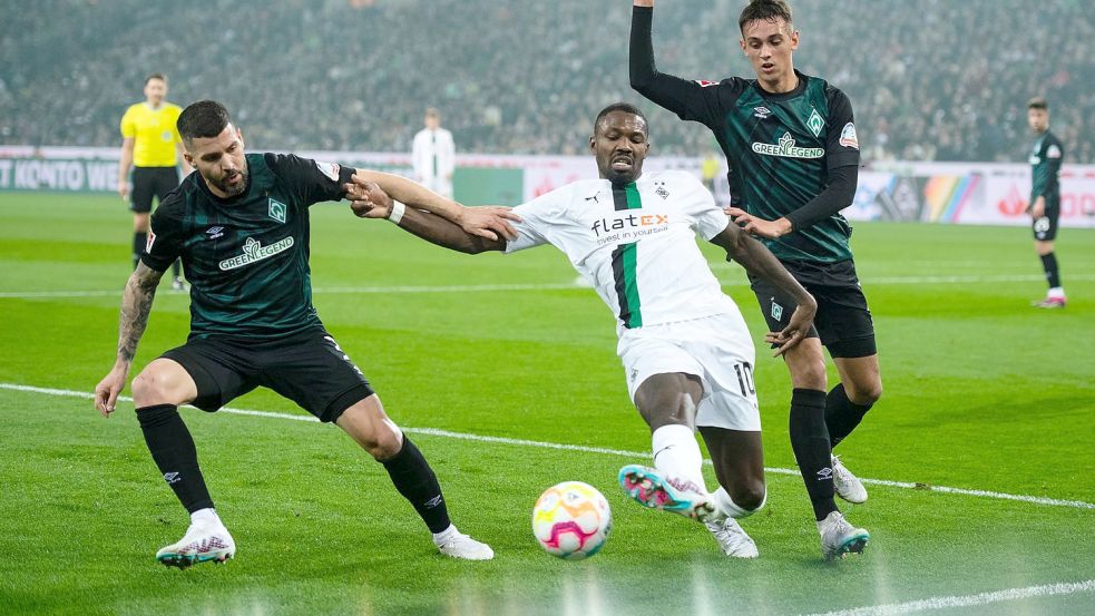 Gladbachs Marcus Thuram (M) kämpft mit Bremens Anthony Jung (l) und Fabio Chiarodia um den Ball. Foto: Marius Becker/dpa