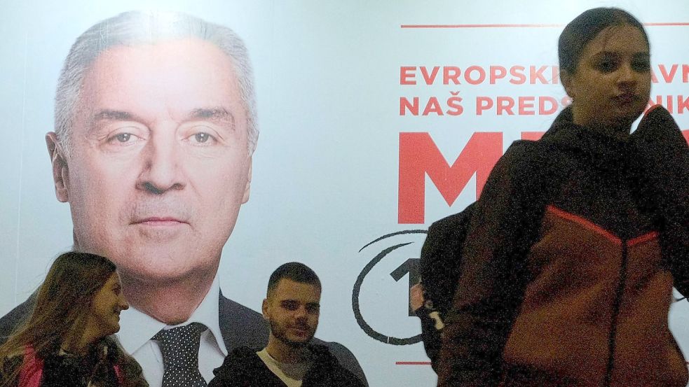 Der Wahlkampf ist zu Ende: Menschen gehen an einem Plakat des pro-westlichen Amtsinhabers Milo Djukanovic vorbei. Foto: Risto Bozovic/AP/dpa