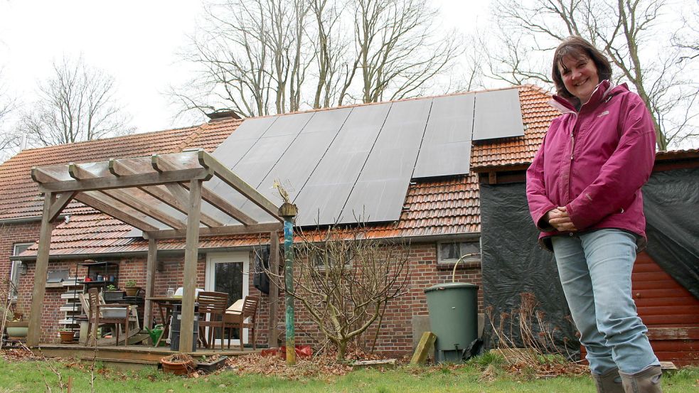 Uli Maus im Garten ihres Hauses in Moorweg. Das Dach ziert seit neuestem eine Photovoltaikanlage. Foto: Oltmanns