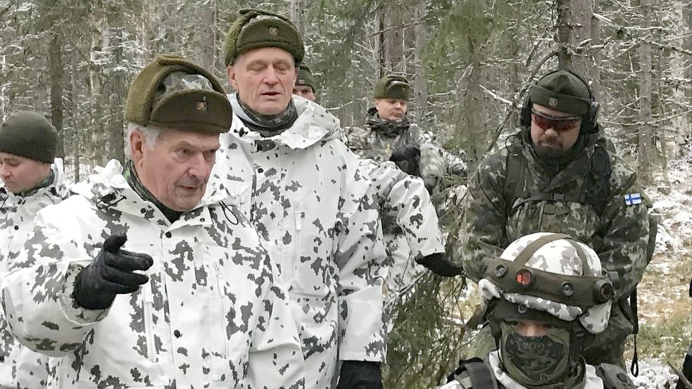 Finnlands Staatspräsident Sauli NIinistö (l.) bei einem Manöver im Wald. Foto: Jens Mattern