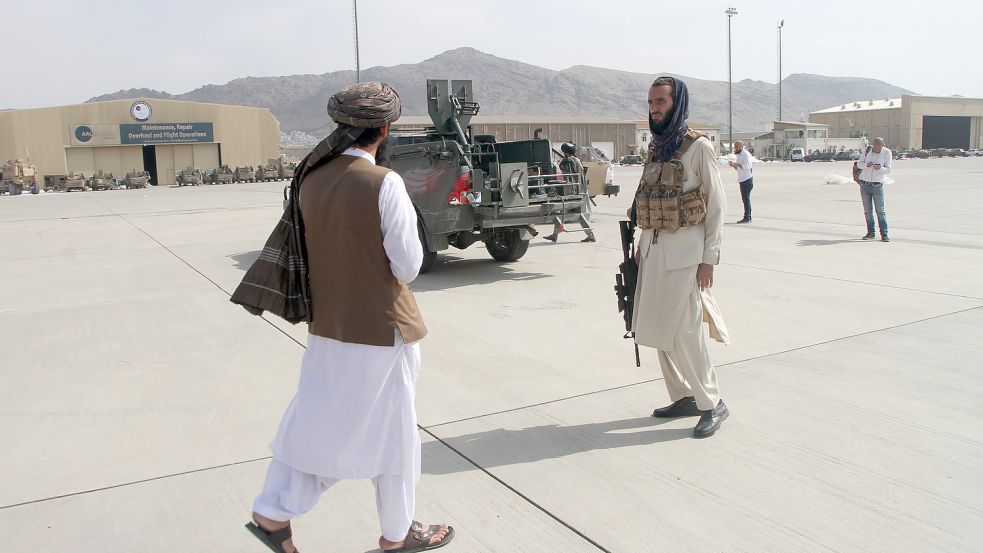Mitglieder der Taliban gehen nach dem Abzug der US-Truppen Ende August 2021 über den Flughafen Kabul. Foto: dpa/XinHua