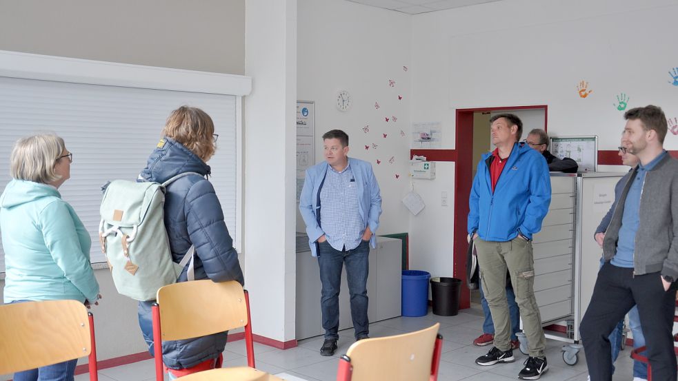 Schulleiter Klaus Saathoff zeigt den Ausschussmitgliedern die Mensa der Grundschule Riepe. Derzeit speisen hier zusätzlich 27 Kinder der angrenzenden Kita "Zwergennest". Foto: Kim Hüsing