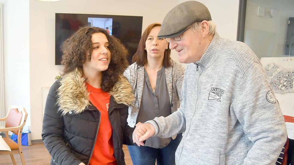 Melissa führt Klaas, für den sie die Patenschaft übernommen hat, vorsichtig zu seinem Platz. Im Hintergrund Bianca Flapper von der Einrichtung Awo-Wohnpark „Up Fehn“. Foto: Gerd-Arnold Ubben