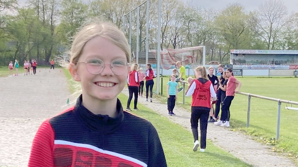 Fenna Schoon hat gut lachen. Sie führt die Jugendwertung beim Ossiloop an. Im Hintergrund trainieren die Mädchen der SVG-Leichtathletikabteilung. Foto: Marco Lindenbeck