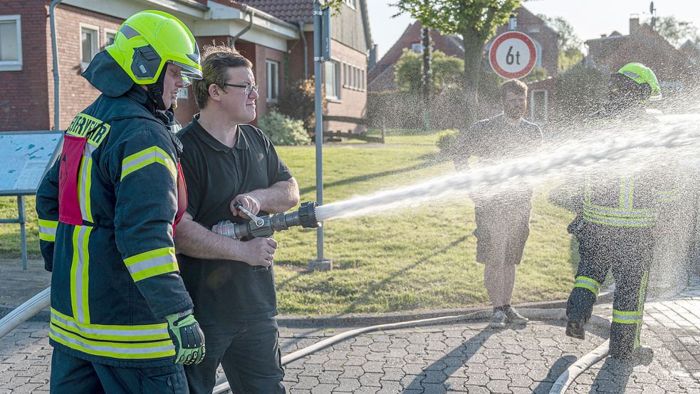 Wasser marsch: Besucher des Schnupper-Dienstabends bei der Wirdumer Feuerwehr durften sich im Umgang mit Strahlrohren versuchen. Foto: Folkert Bents