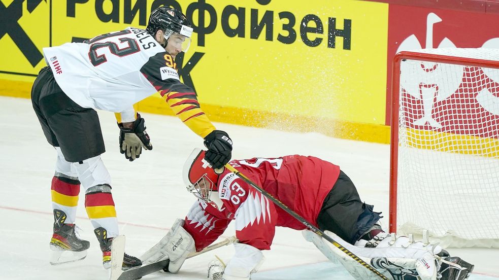 Deutschlands Marcel Noebels schießt den Puck am Schweizer Torwart Leonardo Genoni vorbei. Am Donnerstag kommt es in Riga zum WM-Viertelfinale gegen die Schweiz. Foto: Roman Koksarov/dpa