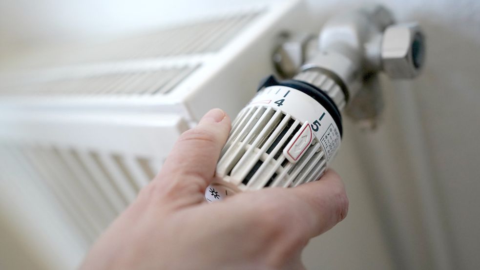 Am Thermostat eines Heizkörpers wird gedreht. Foto: DPA
