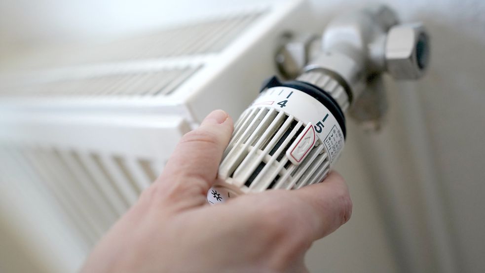 Am Thermostat eines Heizkörpers wird gedreht. Foto: DPA