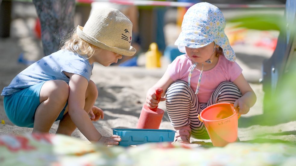 Mädchen einer Krippengruppe spielen im Sand. Die Nachfrage nach Betreuung für die Kleinsten steigt auch in der Gemeinde Ihlow an. Foto: DPA