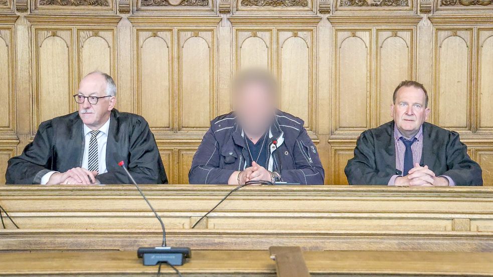 Der Angeklagte (M) sitzt vor der Urteilsverkündung im Prozess wegen Mordes im Landgericht Bremen zwischen seinen Verteidigern. Foto: Focke Strangmann/dpa
