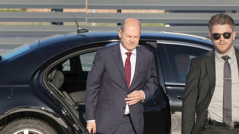 Bundeskanzler Olaf Scholz (l, SPD) kommt zum Start einer zweitägigen Reise auf dem militärischen Teil des Flughafens Berlin Brandenburg BER an und steigt aus einer Limousine. Foto: Soeren Stache/dpa