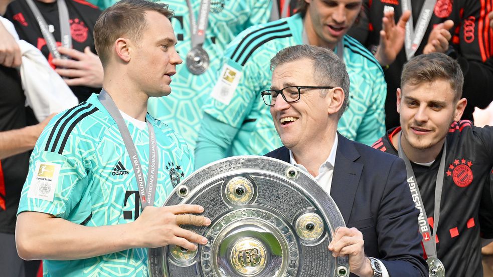 Jan-Christian Dreesen (rechts) mit Manuel Neuer und Meisterschale. Foto: DPA