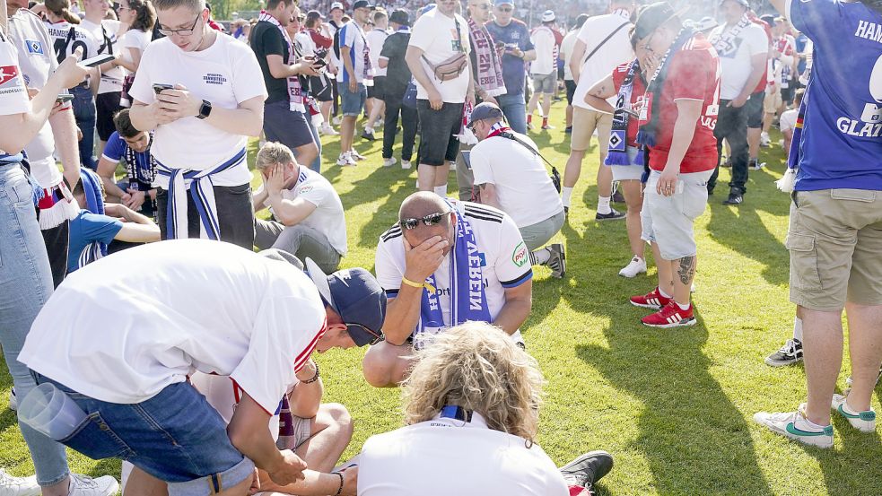 Die Fans des Hamburger SV können es nicht fassen: Sie hatten zuvor in Sandhausen minutenlang den vermeintlichen Aufstieg gefeiert, ehe die Konkurrenz aus Heidenheim mit zwei Toren in der Nachspielzeit das Ticket für die Bundesliga löste. Ein Tiefschlag für die HSV-Anhänger. Foto: DPA