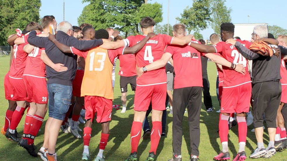 Spieler, Trainer, Betreuer und Funktionsträger der SpVg Aurich tanzten und hopsten nach Spielschluss eng beieinander Arm in Arm auf dem Sportplatz in Jheringsfehn. Die Auricher haben wie in der Vorsaison erst am letzten Spieltag den Ligaverbleib perfekt gemacht. Und so hallte es auch am frühen Sonnabendabend „Unabsteiger, Unabsteiger“ über das Gelände. Fotos: Wolf-Rüdiger Saathoff