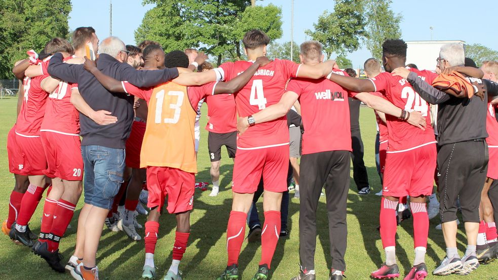 Spieler, Trainer, Betreuer und Funktionsträger der SpVg Aurich tanzten und hopsten nach Spielschluss eng beieinander Arm in Arm auf dem Sportplatz in Jheringsfehn. Die Auricher haben wie in der Vorsaison erst am letzten Spieltag den Ligaverbleib perfekt gemacht. Und so hallte es auch am frühen Sonnabendabend „Unabsteiger, Unabsteiger“ über das Gelände. Fotos: Wolf-Rüdiger Saathoff